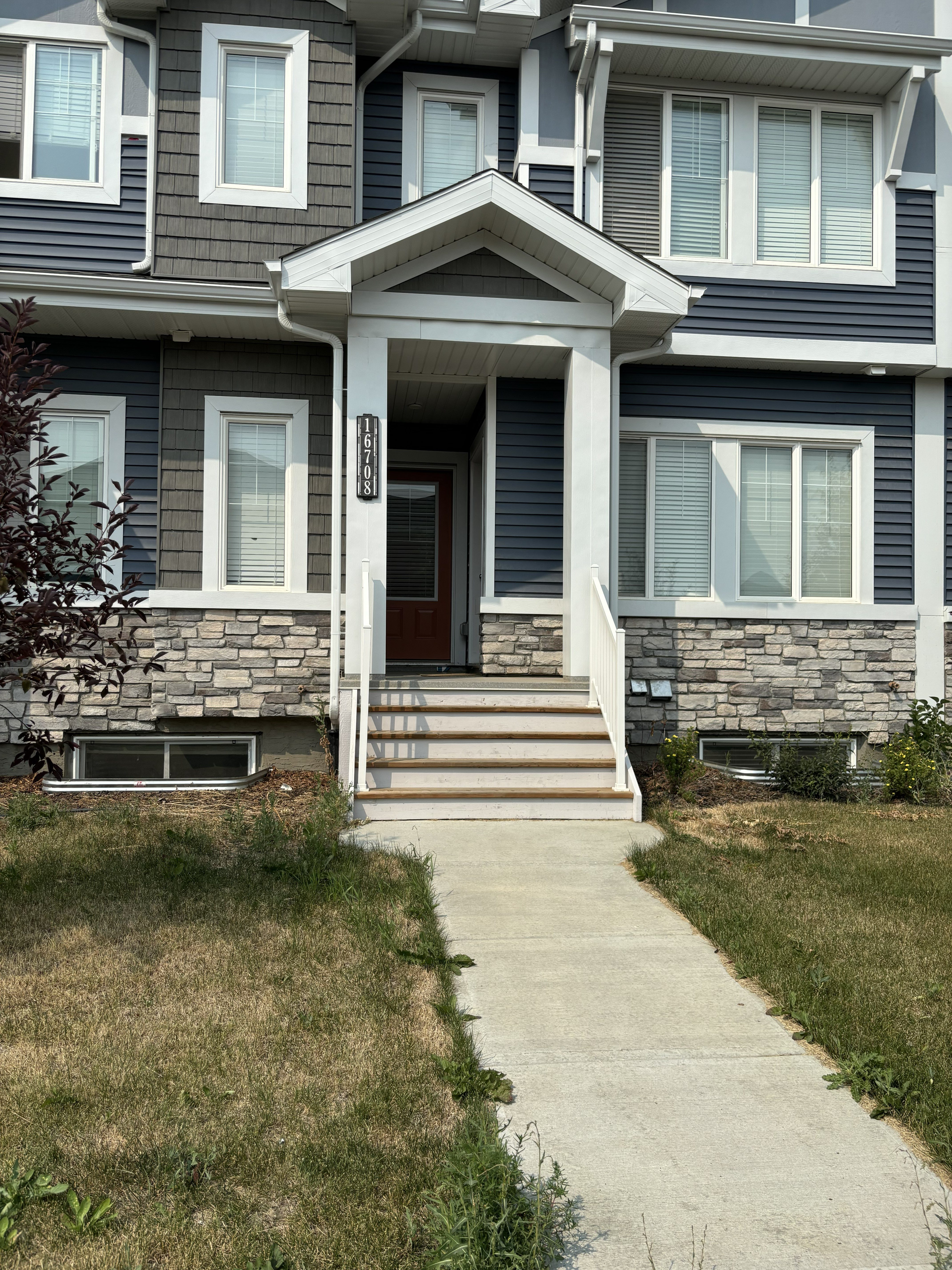 A house with a grey front and a brown door.